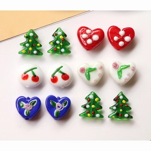 Macro detail of colorful heart, cherry and Christmas tree shaped DIY handmade glass beads