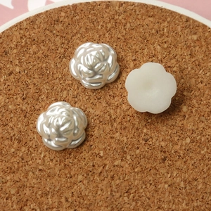 Macro detail of pearlescent white resin rose charms for DIY jewelry and phone case crafts