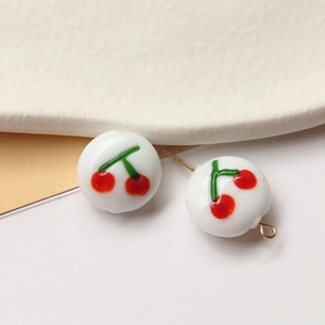 Macro detail of cherry pattern white glazed beads with gold metal jewelry fittings