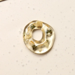 Detail view of irregular resin ring with white dried flowers and micro pearls for DIY crafts