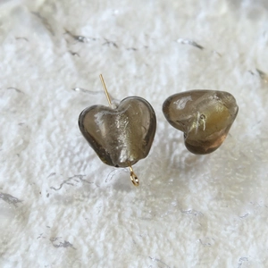 Dettaglio di perle in vetro grigio a cuore con glitter dorati per creazione gioielli DIY