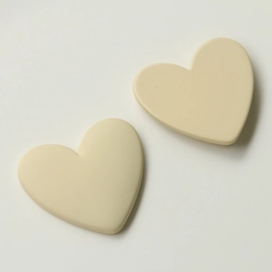 Detail of cream yellow heart-shaped DIY resin patches with a matte frosted texture