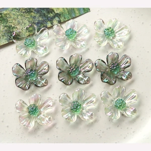 Detailed view of nine translucent colorful resin daisy charms with green textured centers