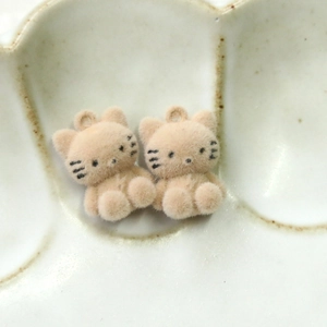 Detailed macro view of plush milk tea colored cat charms for DIY crafts and jewelry