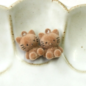 Detailed close-up of brown flocked cat charms for DIY jewelry and hair accessories