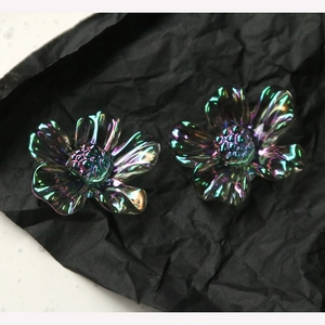 Macro shot of iridescent resin daisy petals with rainbow shimmer on dark background