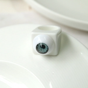Macro detail of white square resin ring featuring a realistic blue eyeball design