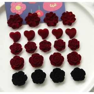 Macro shot of burgundy flocked flower and heart resin charms for DIY jewelry making