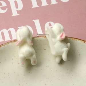 Macro shot showing detail of soft flocked rabbit earrings with pink paws and silver studs