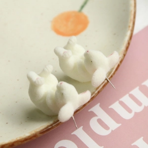 Cute white flocked rabbit stud earrings with pink ears on a cherry pattern plate