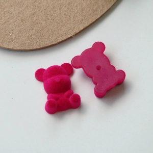Macro detail of magenta flocked teddy bear DIY charm with flat back and center hole