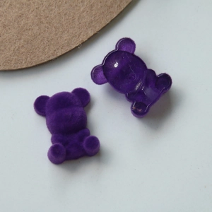 Detailed view of DIY teddy bear charms in purple flocking and translucent resin texture