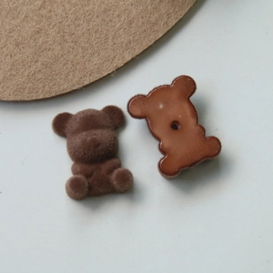 Detail view of dark brown flocked teddy bear acrylic patch with smooth plastic backing