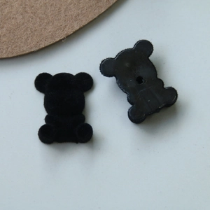 Macro detail of flocked black teddy bear DIY accessory showing fuzzy texture and back view