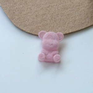 Macro shot of pink flocked teddy bear DIY accessory with soft textured velvet surface