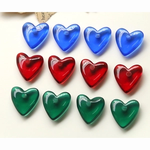 Détail de boutons en résine transparente en forme de cœur, couleurs bleu, rouge et vert