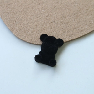 Detailed view of a black flocked teddy bear DIY accessory with soft velvet texture