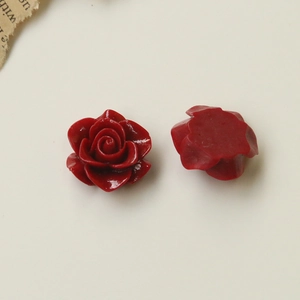 Macro shot of resin red camellia charms showing front petals and flat back for DIY