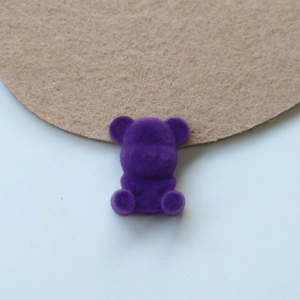 Detailed view of a purple flocked teddy bear patch for DIY jewelry and accessories