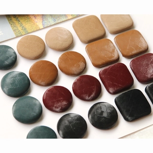 Macro shot of assorted faux snake skin velvet buttons in vintage square and round shapes