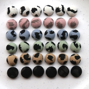 Macro detail of 36 round leopard print fabric buttons in six different colors