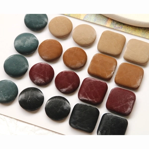 Detailed view of assorted geometric faux leather buttons with vintage snake pattern