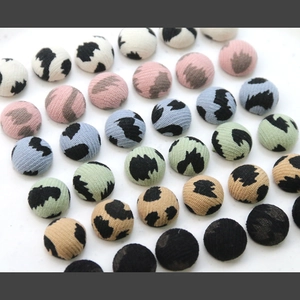 Macro detail of mixed color leopard print fabric covered buttons for DIY jewelry