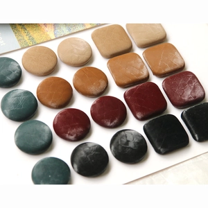 Detailed view of leather covered buttons in various shapes and vintage autumn colors