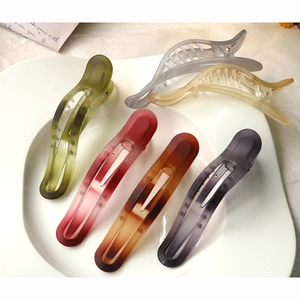 Matte resin hair clips in six colors arranged in a white ceramic dish accessory