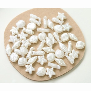 Macro shot of pearl white starfish and seashell resin charms for DIY jewelry making