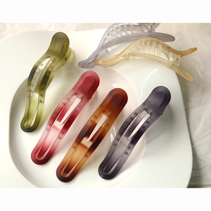 Colorful matte resin hair clips set in olive, amber, and gradient tones on white fabric
