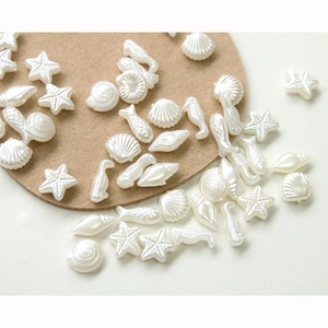 Detailed view of sea-themed pearl white DIY beads including starfish and shell shapes