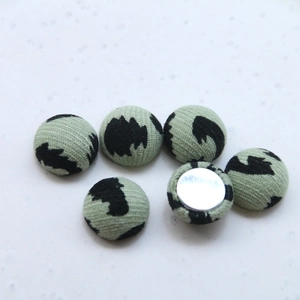 Close-up of light green leopard print fabric buttons for DIY handmade jewelry crafts