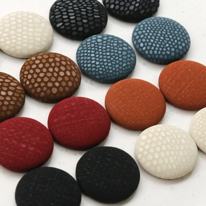 Assorted circular fabric buttons with snakeskin and pebble textures for DIY sewing and crafts