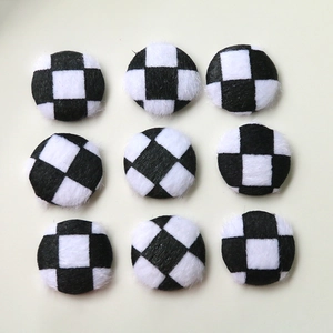 Macro view of 9 black and white checkered plush round buttons for DIY coat and jewelry