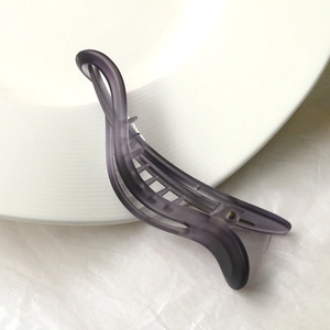 Close-up of matte purple banana hair clip with internal interlocking teeth for secure grip