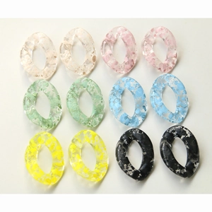 Flat lay of translucent ink-patterned acrylic oval links for DIY jewelry making