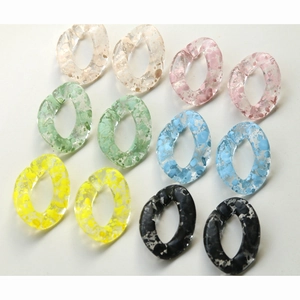 Close-up of multicolored acrylic chain links with ink-splatter texture for DIY crafts