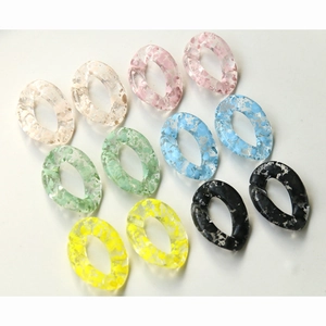 Detail of translucent acrylic oval chain links with colorful ink splatter effect for DIY
