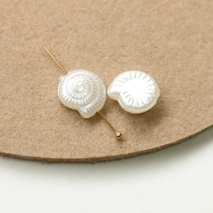 Detailed view of pearlized nautilus shell beads with delicate spiral texture for DIY crafts