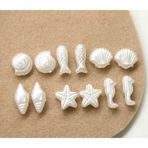 Macro shot of assorted faux pearl sea life charms like starfish and shells for DIY
