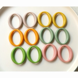 Macro shot of 12 colorful oval acrylic jewelry pendants in vibrant macaron pastel colors