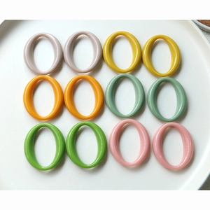 Colorful oval acrylic links for DIY jewelry making displayed in a white ceramic dish