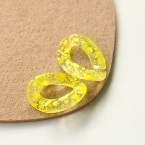 Macro view of semi-transparent yellow ink splatter acrylic chain link jewelry parts