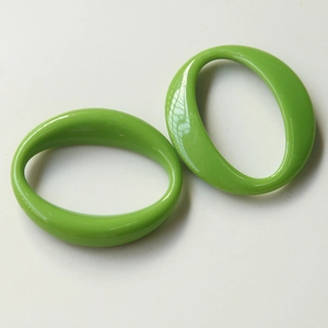 Close-up of polished green oval acrylic pendant frames for DIY jewelry and hair accessories