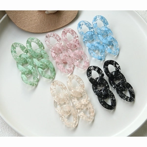 Close-up of colorful acrylic link chains with ink splatter texture for DIY jewelry making