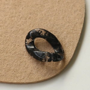 Detail of translucent black ink-splatter acrylic chain links for DIY accessory crafting