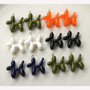 Macro view of colorful resin balloon dog pendants with golden metal hanging rings