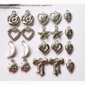 Macro view of assorted silver alloy charms including hearts, stars, and moon for DIY jewelry