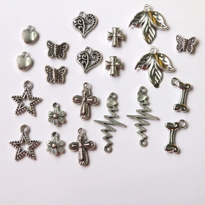 Detailed close-up of mixed alloy charms including hearts and butterfly for DIY jewelry making